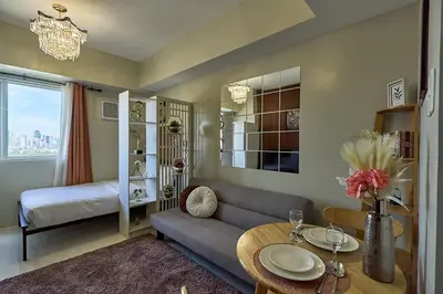 a living room with a couch and a table at Vista Blooms Stay at Vista Shaw with WiFi in Manila