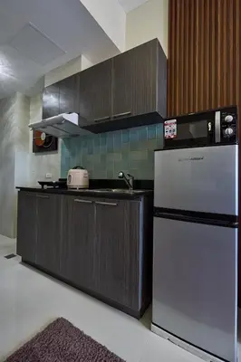 a kitchen with a stainless steel refrigerator and cabinets at Vista Blooms Stay at Vista Shaw with WiFi in Manila