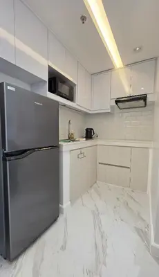 a kitchen with a stainless steel refrigerator at Center of BGC- Your Home In Forbeswood Parklane in Manila