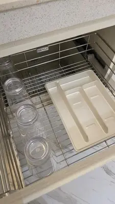 a drawer in a refrigerator with a tray and glasses at Center of BGC- Your Home In Forbeswood Parklane in Manila
