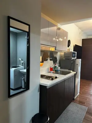 a kitchen with a sink and a refrigerator at MySunset at Air Residences Makati in Manila