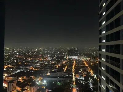 a city skyline at night with a tall building at MySunset at Air Residences Makati in Manila