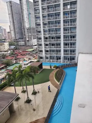 a person standing in front of a large building at SMDC Breeze Residences in Manila