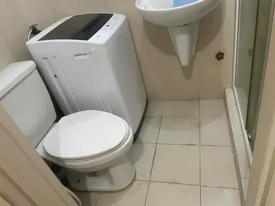 a small bathroom with a toilet and a sink at 1 BR Family Condo near NAIA behind SM Sucat Paranaque Manila Philippines in Manila