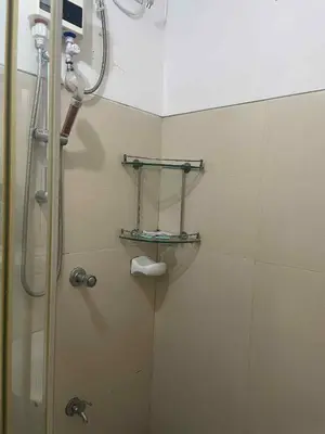 a shower in a bathroom with a glass shower stall at 1 BR Family Condo near NAIA behind SM Sucat Paranaque Manila Philippines in Manila
