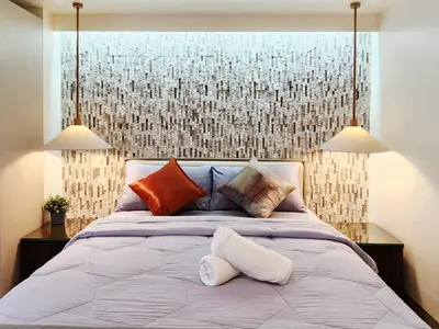 a bedroom with a large bed with two lamps at 29c BGC Cozy Suite Steps Away From Major Malls with Paid Parking and Gym with Fast Wi-fi in Manila