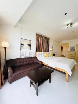 a bedroom with a large bed and a couch at Alex Staycation Home in BGC in Manila