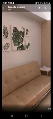 a couch in a room with some plants on the wall at Sea Residences By Queen in Manila