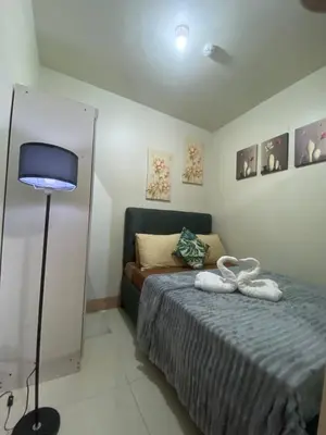a bedroom with a bed with two towels on it at The Residence Suite in Manila