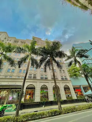 a large building with palm trees in front of it at 101 Newport Blvd - SkyBison Aerie Condo Across NAIA T3 in Manila
