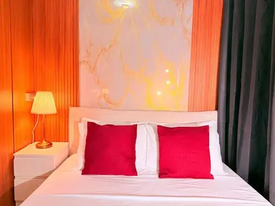 a bed with two red pillows in a bedroom at Cozy, budget-friendly stay for families and friends at Shell Residences by ONE Guest Place in Manila