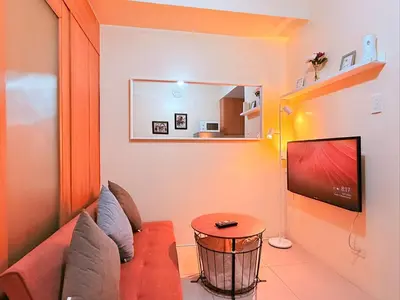 a living room with a couch and a television at Cozy, budget-friendly stay for families and friends at Shell Residences by ONE Guest Place in Manila