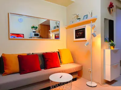 a living room with a couch with colorful pillows at Cozy, budget-friendly stay for families and friends at Shell Residences by ONE Guest Place in Manila