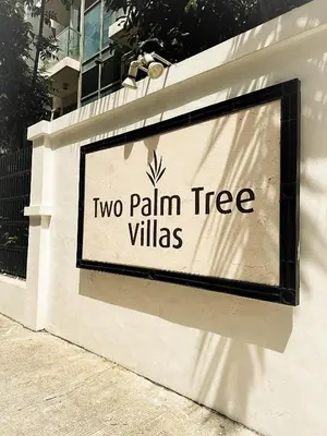 a sign for two palm tree villas on a wall at Kai cabins NAIA 3 walking distance Newport City Pasay in Manila