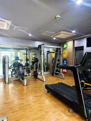 a gym with several tread machines in a room at Kai cabins NAIA 3 walking distance Newport City Pasay in Manila