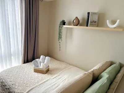 a bedroom with a bed with a basket of towels at Kasara Urban Residences in Pasig City - Solmera Cove in Manila