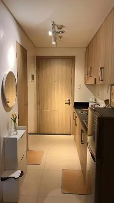 a kitchen with a refrigerator and a door to a room at Family Room Staycation Shore Residences Near Mall of Asia and Airport Adjacent Units - Perfect for Groups in Manila