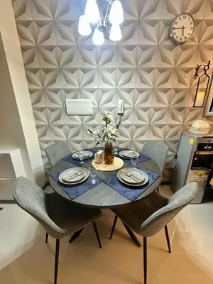 a dining room table with chairs and a clock on a wall at Stay at Downtown Suite 2 in BGC, Taguig City in Manila