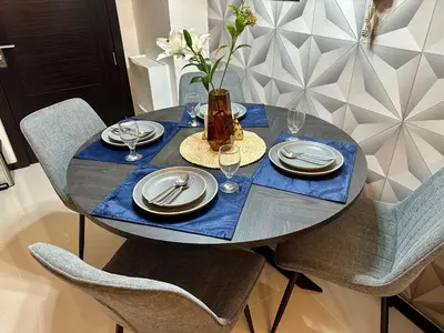 a blue table with plates and glasses and a vase at Stay at Downtown Suite 2 in BGC, Taguig City in Manila