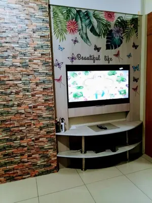 a flat screen tv sitting on top of a brick wall at MOA Staycation - Shell Condo in Manila