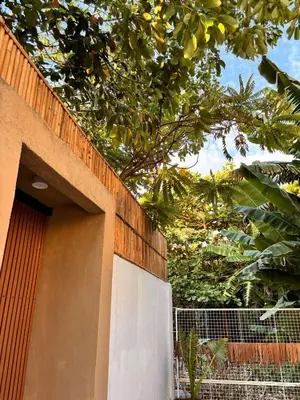 a building with a fence next to a tree at Kamia Tiny Rest House in Sampong