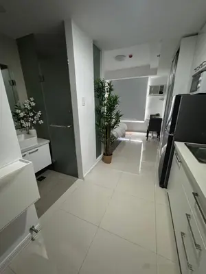a white kitchen with a plant in the middle of it at La Casa Zen - Cozy Studio with private Wi-Fi, complimentary access to Fitness Centre, swimming pool and stunning city view located near the CBD of Ortigas, Makati, BGC in Manila