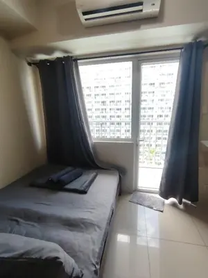 a bedroom with a bed and a large window at Shell residences Near Moa Japs staycation in Manila