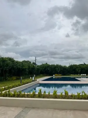 a swimming pool in a park with a cloudy sky at RM South Staycation in Biñan