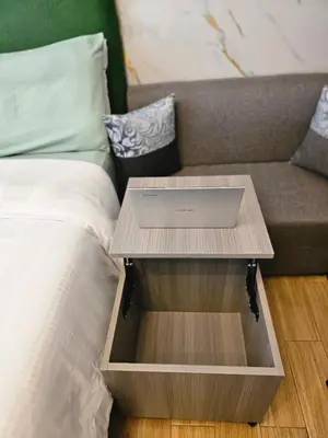 a table with a laptop on top of a bed at RM South Staycation in Biñan