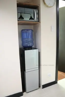 a kitchen with a refrigerator and a microwave on a shelf at 2BR Condo - Makati CBD, Sunset Views, 20mins to NAIA in Manila