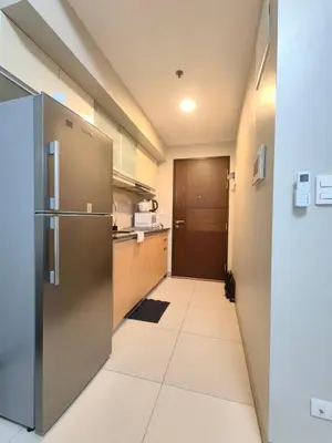 a kitchen with a stainless steel refrigerator and a hallway at Uptown BGC 1BR Modern Pool View Unit by Terravista in Manila