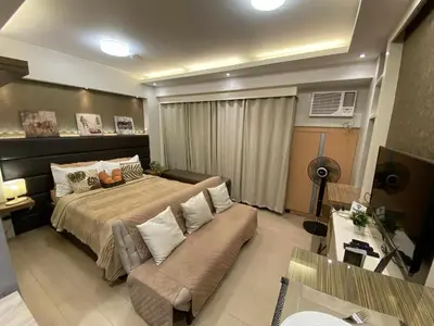 a large bedroom with a bed and a couch at Bekipay Suite at Two Palm tree across NAIA 3 in Manila