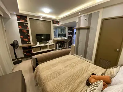 a bedroom with a bed and a desk and a television at Bekipay Suite at Two Palm tree across NAIA 3 in Manila