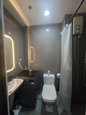 a small bathroom with a toilet and a sink at Air Residences Makati in Manila