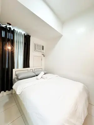 a white bedroom with a large white bed in it at Vanity Calm Bedroom in Ortigas Center in Manila