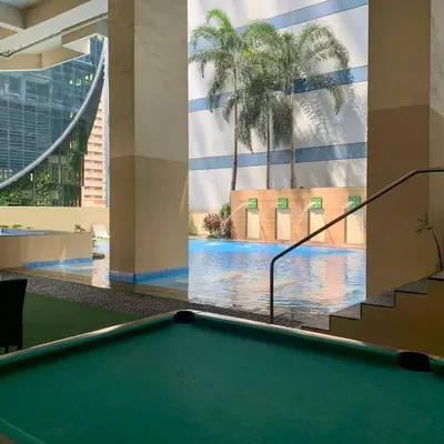 a pool table in a hotel lobby with a swimming pool at Vanity Calm Bedroom in Ortigas Center in Manila