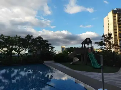 a playground with a slide next to a pool at Makati Staycation at Air Residences in Manila