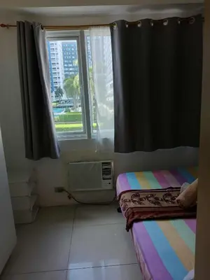 a room with a window and a bed and a sink at Sea residences Christine prime in Manila