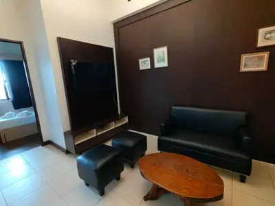 a waiting room with a couch and a table and a tv at Apartment in Rhapsody 2BR in Manila
