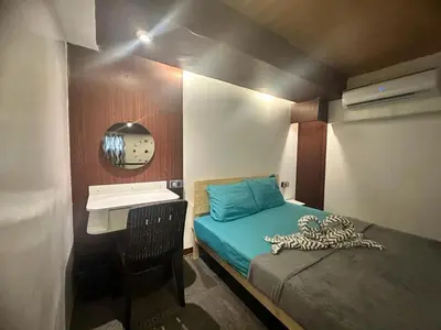a small bedroom with a bed and a sink at Adorable - 2B, Stunning Lounge in Manila