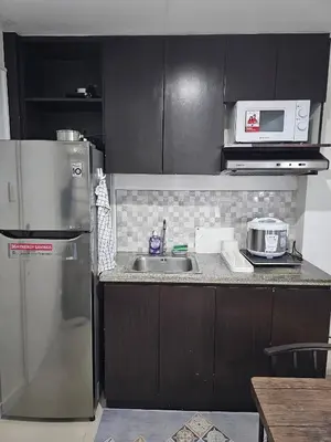 a kitchen with a sink and a refrigerator at Casa Rosa3 2BR loft in BGC 5 people in Manila