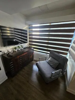 a living room with a chair and a large window at Casa Rosa3 2BR loft in BGC 5 people in Manila