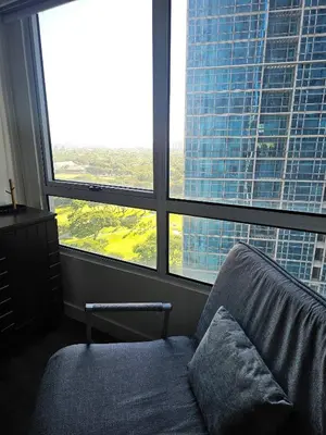 a room with a couch in front of a large window at Casa Rosa3 2BR loft in BGC 5 people in Manila