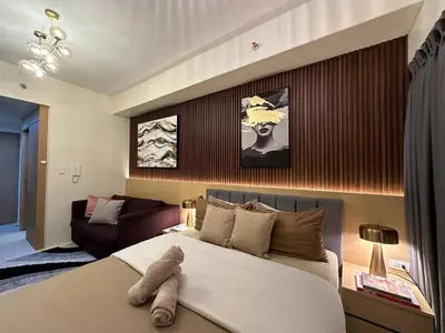 a bedroom with a large bed and a couch at Red Residences in Manila