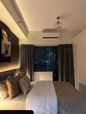 a bedroom with a large bed with a window at Red Residences in Manila