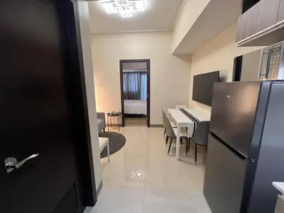 a kitchen and dining room with a table and a refrigerator at Parkwest McKinley - 1 Bedroom Fully Furnished in Manila