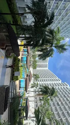 a tall building with palm trees in front of it at MOA Shell Residences Staycation in Manila