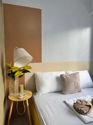 a bed with a lamp and a vase of flowers on a table at Shore Residences Banana Room with 2 Beds Good for 4 Guests Pool View Room 622 by Prime Stay in Manila