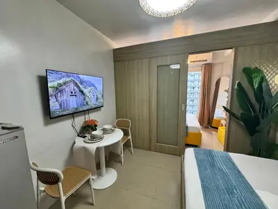 a bedroom with a bed and a table and a tv at Shore Residences Banana Room with 2 Beds Good for 4 Guests Pool View Room 622 by Prime Stay in Manila
