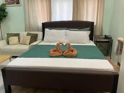 two towels sitting on top of a bed at Seb and Santi Holland Park Staycation in Biñan